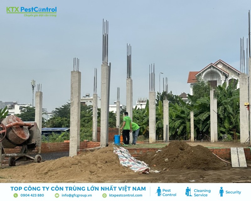 Kỹ thuật viên tiến hành tưới thuốc phòng mối lên móng và chân trụ sau khi đan sắt xong